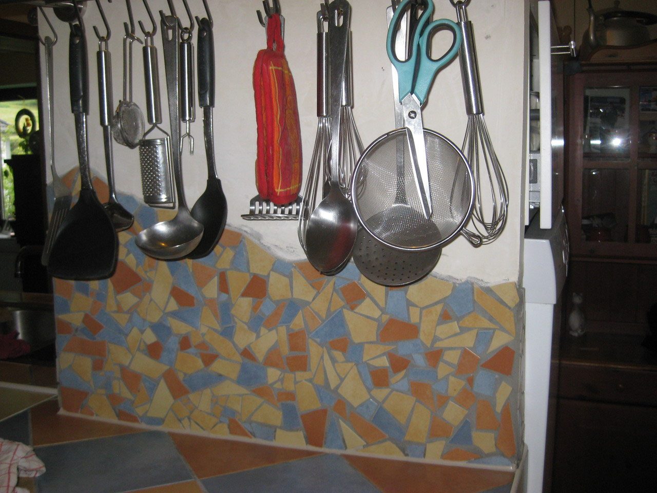 Küchenrückwand mit Mosaik aus Fliesenbruch in Ocker, Blau und Terrakotta