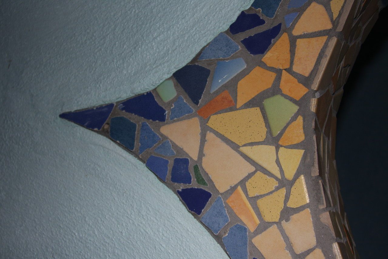 Mosaikband auf einer geschwungenen, hellblau verputzten Wand
