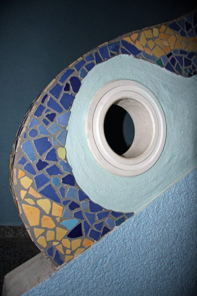 Treppengeländer aus Putz mit Mosaikband und rundem Durchblick