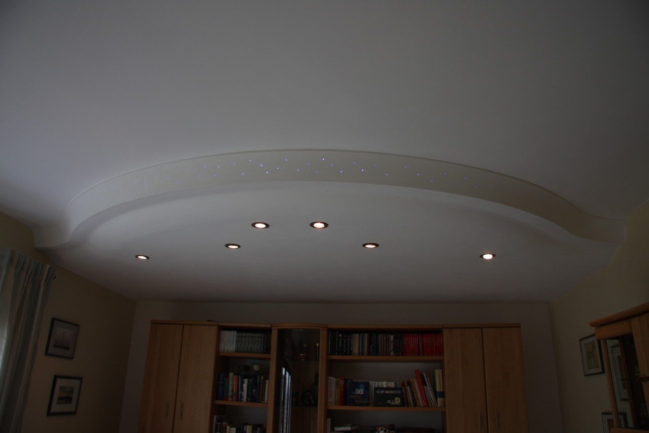 Elliptische Lichtvoute aus Stuck mit Einbauspots an einer Wohnzimmerdecke