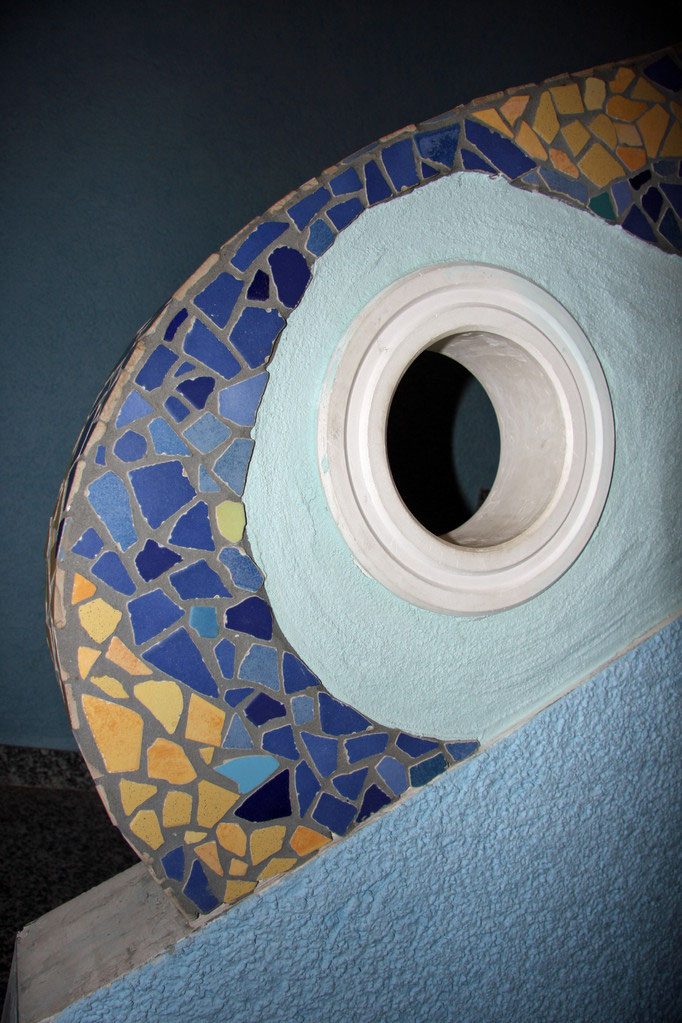 Treppengeländer aus Putz mit Mosaikband und rundem Durchblick